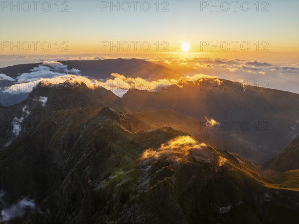 Aerial drone view of mountains over clouds near Pico Ruivo on sunset. Madeira island, Portugal, Europe
