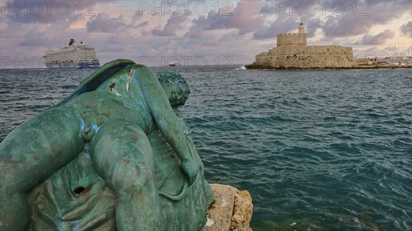 A damaged sculpture looks out over the sea and a fortress during a dramatic sunset, sky exchanged, sculpture Sleeping Eros, cruise ship, Fort of Saint Nikolaos, harbour area, Rhodes Town, Rhodes, Dodecanese, Greek Islands, Greece, Europe