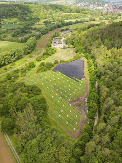 Aerial view of solar installations in a green landscape on the edge of a forest in a rural setting, construction of the Black Forest Nature solar park, Weil der Stadt, Germany, Europe