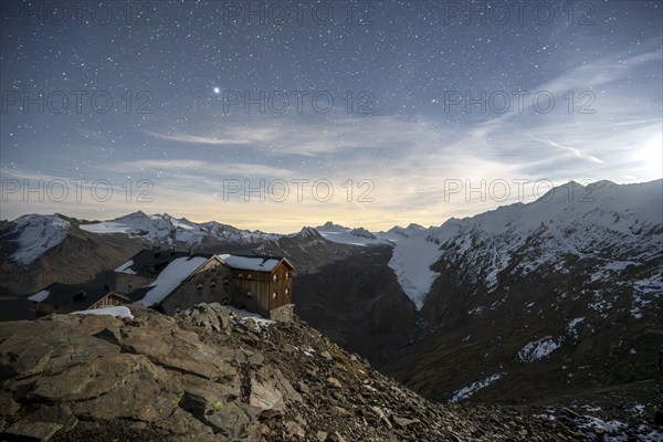 Mountain landscape under a starry sky, night shot, mountain hut Ramolhaus in autumn with snow, view of Gurgler Ferner with summit Hochwilde and Falschungsspitze, Ötztal Alps, Tyrol, Austria, Europe
