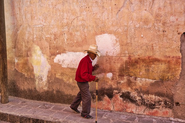 San Miguel de Allende, Mexico-3 December, 2018: Old man walking down the streets of San Miguel de Allende in historic city center
