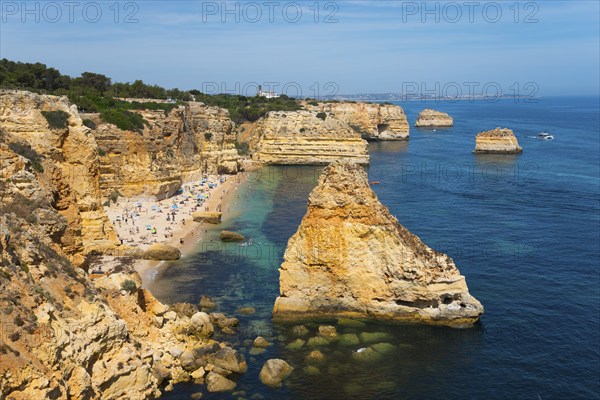A beautiful beach on a rocky coast with clear blue water and sunny skies, Praia da Marinha, Lagoa, Rocky Algarve, Algarve, Portugal, Europe