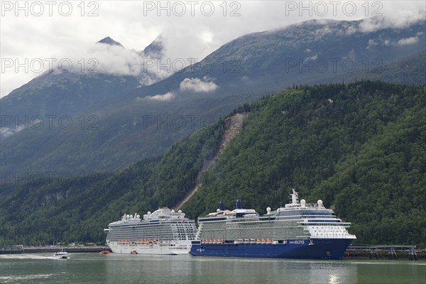 Two large cruise ships in front of high mountains in the harbour of Skagway, Alaska, USA, North America