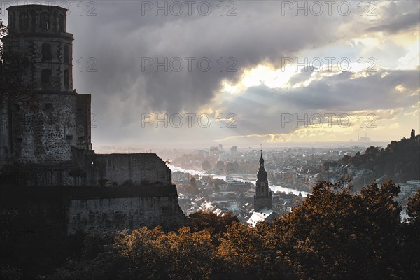 Romantic view of the city of Heidelberg with river and castle under a dramatic sky and falling light, Heidelberg, Germany, Europe