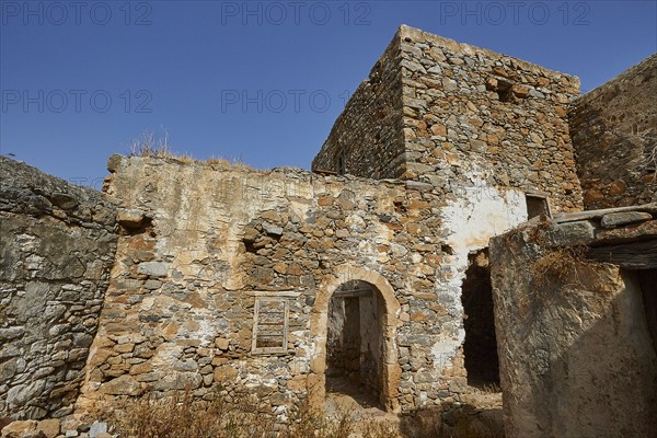 Abandoned stone houses and ruins under a clear blue sky on a sunny day, Venetian Sea Fortress, Leper Island, Spinalonga, Elounda Bay, Mirabello Bay, East Crete, Crete, Greek Islands, Greece, Europe
