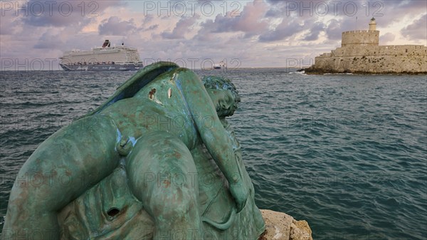 A damaged sculpture looks out over the sea and a fortress during a dramatic sunset, sky exchanged, sculpture Sleeping Eros, cruise ship, Fort of Saint Nikolaos, harbour area, Rhodes Town, Rhodes, Dodecanese, Greek Islands, Greece, Europe
