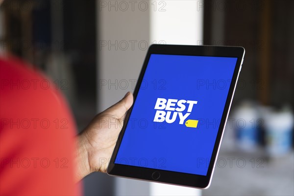 Best Buy logo is displayed on smartphone. Best Buy Co., Inc. is an American multinational consumer electronics retailer