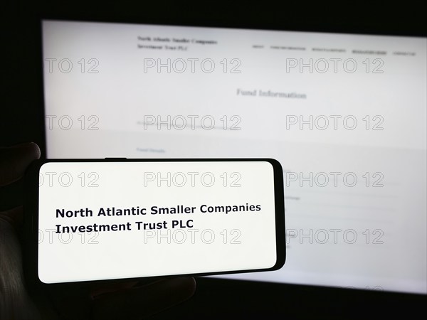 Stuttgart, Germany, 03-25-2024: Person holding smartphone with logo of North Atlantic Smaller Companies Investment Trust plc in front of website. Focus on phone display, Europe