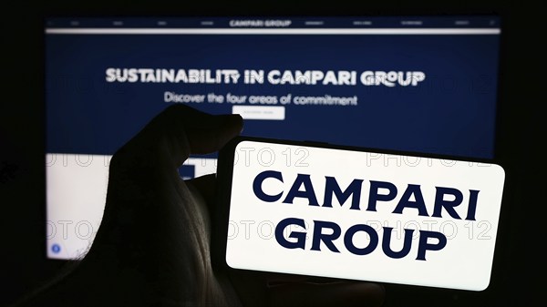 Stuttgart, Germany, 06-01-2024: Person holding smartphone with logo of Italian spirits company Davide Campari-Milano N.V. in front of website. Focus on phone display, Europe