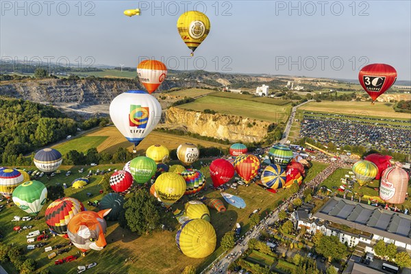 Colourful hot-air balloons at mass launch, crowd on fairground, hot-air balloon festival, 26th Warsteiner International Montgolfiade, aerial view, Warstein, Sauerland, North Rhine-Westphalia, Germany, Europe