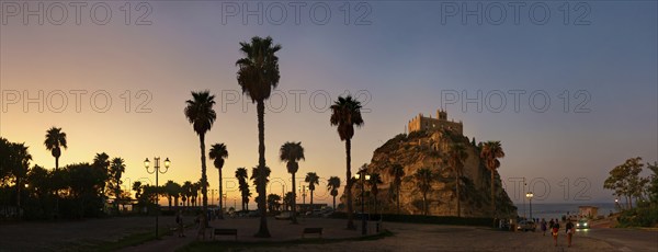Parking with palm trees overlooking the medieval church Santuario di Santa Maria dell Isola di Tropea built on rocks of sandstone at sunset, Tropea, Calabria, Vibo Valentia, Southern Italy, Italy, Europe