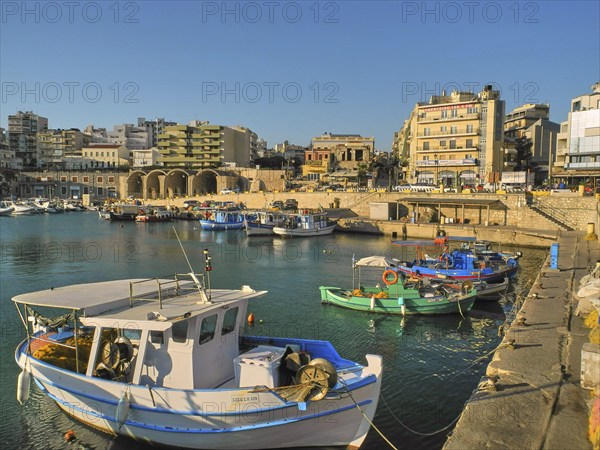 Morning light, fishing boats, old Venetian salt warehouse, houses, blue cloudless sky, harbour, Heraklion, capital, island of Crete, Greece, Europe