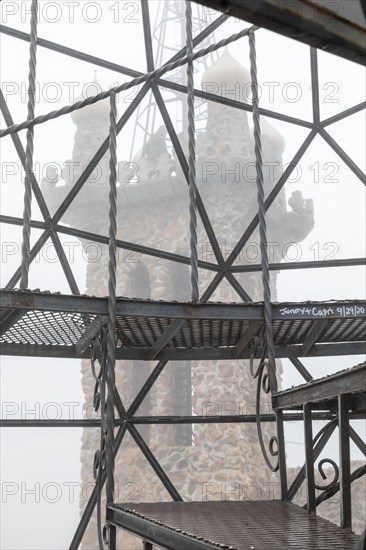 Rye, Colorado, Towers of Bishop Castle on a foggy morning. The Castle is an elaborate stone and metal structure and roadside attraction. It is being built by Jim Bishop in the mountains of San Isabel National Forest