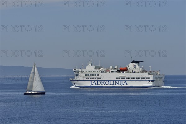 Sailing boat and ferry of the Jadrolinija shipping company, near Split, Dalmatia, Croatia, Europe