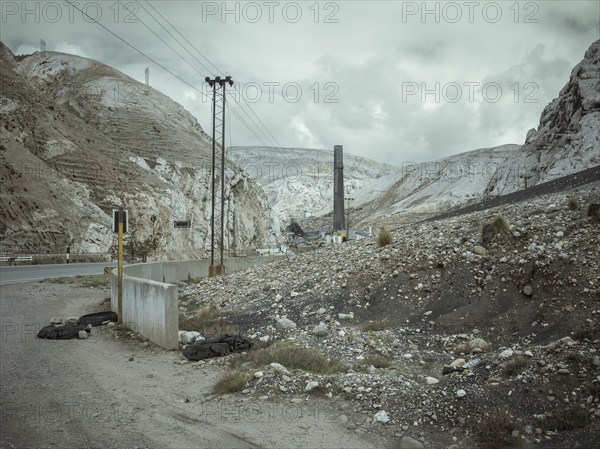 Chimney of the smelter, in the foreground a spoil heap contaminated with heavy metal residues, La Oroya, Peru, South America