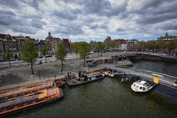 AMSTERDAM, NETHERLANDS, MAY 9, 2017: Aerial view of Amsterdam canal with tourist boats near Amsterdam Centraal