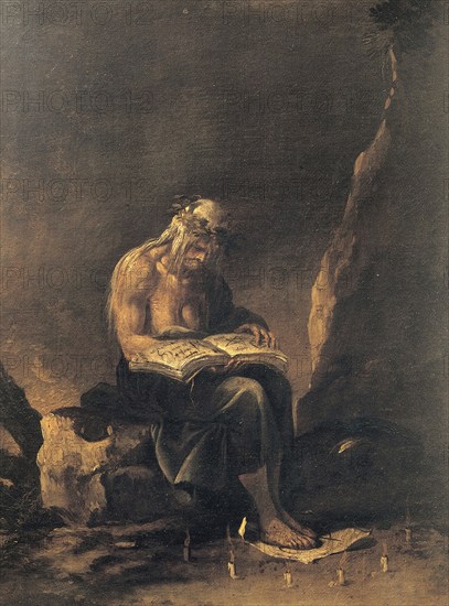 An old witch sits on a rock and reads in a magic book. Around her feet a magic circle of candles, Historic, digitally restored reproduction from an original of the time