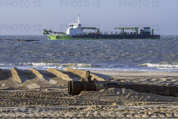 DEME trailing suction hopper dredger Uilenspiegel at sea, used for sand replenishment, beach nourishment to make wider beaches to reduce storm damage
