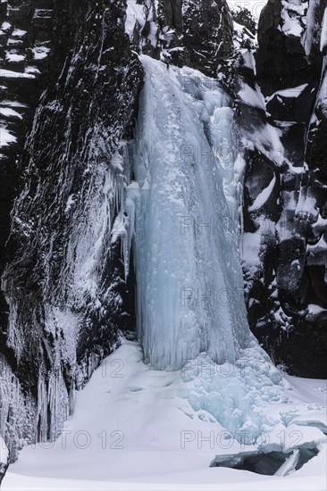 Frozen waterfall, Folaldafoss, snowy rock faceSudausturland, Iceland, Europe
