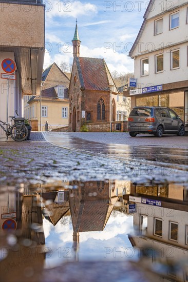 Street through the half-timbered town, historical building with reflection in puddle, Nikolausbrücke, Calw, Black Forest, Germany, Europe