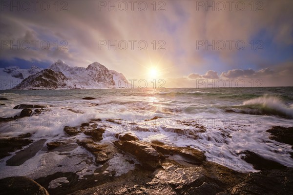 Beach of Norwegian sea on rocky coast in fjord on sunset in winter. Vareid beach, Lofoten islands, Norway, Europe