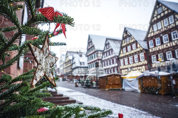 Christmas tree with decorations in front of a snow-covered half-timbered house at a market, Black Forest, Calw, Germany, Europe