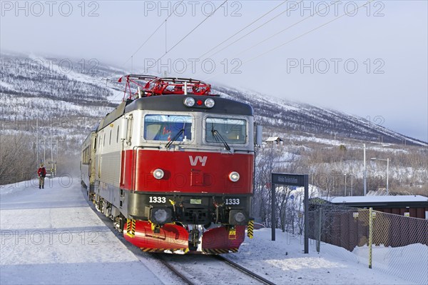 A passenger train in a wintry landscape in Abisko, National Park, Archipelago, Lapland, Sweden, Europe