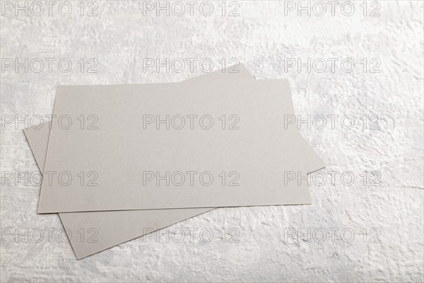Gray paper business card, mockup on gray concrete background. Blank, flat lay, top view, still life, copy space