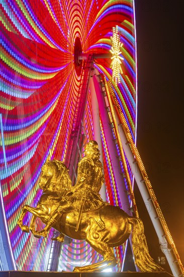 Augustus Market in Dresden. Equestrian statue of Augustus the Strong, also known as the Golden Horseman, with a Ferris wheel turning behind it, Dresden, Saxony, Germany, Europe