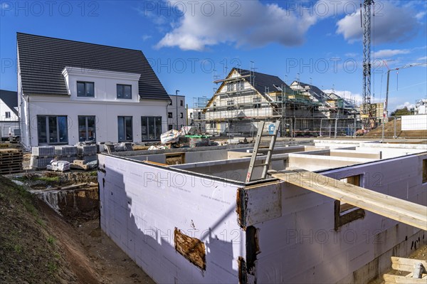 New-build neighbourhood, around 140 detached and semi-detached houses under construction in the south of Duisburg, various developers, shells, construction work, basement, North Rhine-Westphalia, Germany, Europe