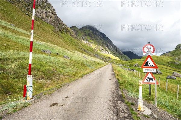 Mountain road from Haukland beach to Uttakleiv, warning signs, no public traffic, be aware of sheep and avalanches, island Vestvågøya, Lofoten, Norway, Europe