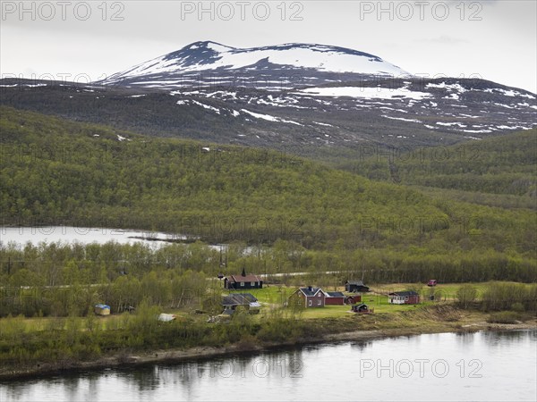 Tana or Tanaelva River, view of small settlement over the river in Norway, which forms the border between Northern Finnish Lapland and Norway, May, Finnmark