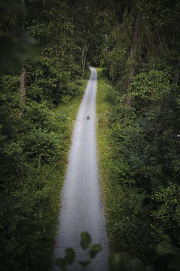 A child on a balance bike rides along a hiking trail through the Höllental valley between Thuringia and Bavaria. Lichtenberg, 21.07.2024
