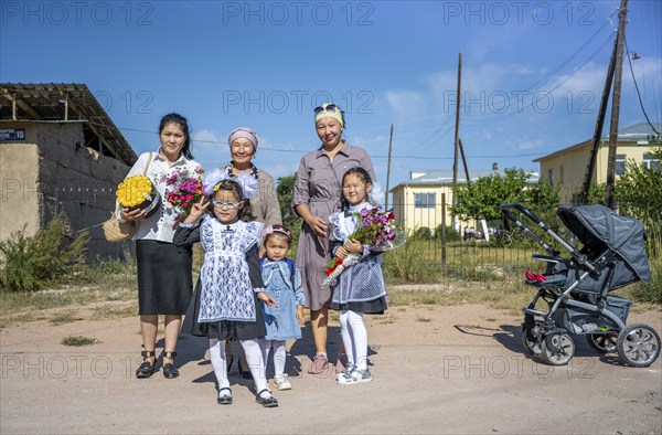 Family and schoolgirl with a bouquet of flowers on the first day of school, Issyk-Kul region, Kyrgyzstan, Asia
