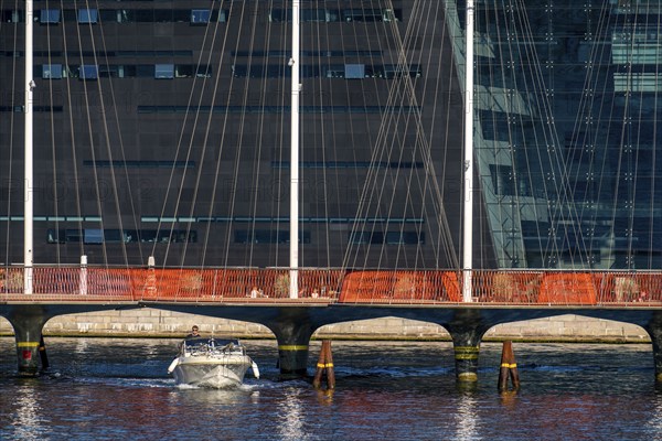 Cyclists on the Cirkelbroen cycle and footpath bridge, over the harbour, in the Christianshavens district, in the background the Danish Royal Library, Black Diamond, Copenhagen is considered the cycling capital of the world, 45 % of the population travel by bike, Denmark, Europe