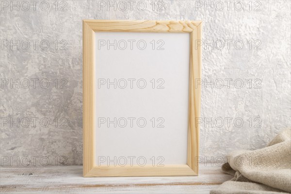 White wooden frame mockup with linen textile on gray concrete background. Blank, vertical orientation, still life, copy space