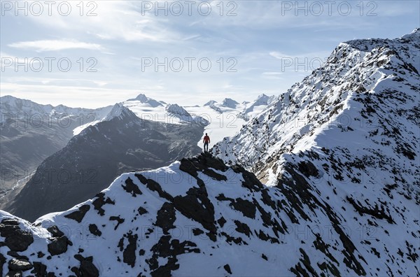 Mountaineer standing on the snow-covered Ramoljoch under a clear sky in the Alps, behind glacier Gurgler Ferner, Obergurgl, Ötztal Alps, Tyrol, Austria, Europe