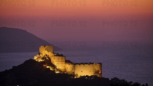 View of an illuminated castle ruin at dusk, surrounded by sea and mountains under a colourful sky, Kritinia Castle, St John's Castle, Kritinia, Rhodes, Dodecanese, Greek Islands, Greece, Europe