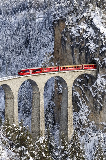Rhaetian Railway train at the famous Landwasser Viaduct on the Albula railway Stadler Rail passenger train in Filisur, Switzerland, Europe