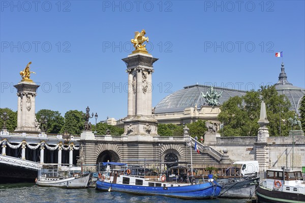 Boats on the river along the monumental bridge with golden sculptures, Paris