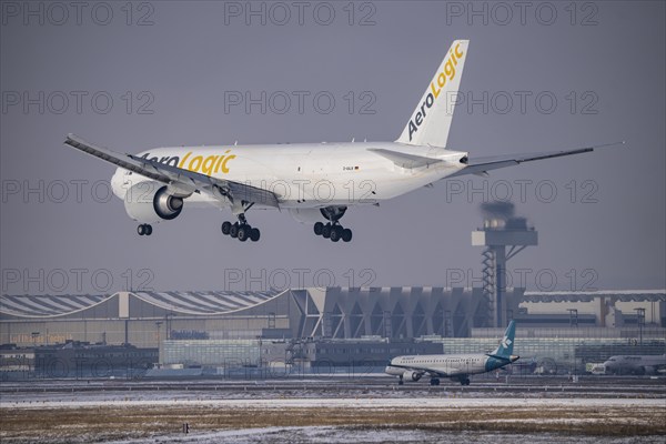 AeroLogic cargo aircraft, Boeing 777F approaching Frankfurt FRA airport, air traffic control tower, Fraport, in winter, Hesse, Germany, Europe