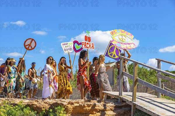 Colourfully dressed youths with musical instruments and banners form a love parade and promote the nightclub Pacha, Cala Comte, Ibiza, Balearic Islands, Mediterranean Sea, Spain, Europe