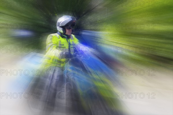 Policeman on a motorbike driving fast along the road, the speed is emphasised by the motion blur, Stuttgart, Baden-Württemberg, Germany, Europe
