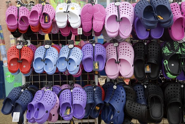 Display of colourful children's plastic Croc beach footwear at the seaside town of Cromer, north Norfolk coast, England, United Kingdom, Europe