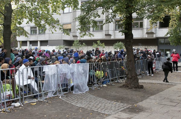 Refugees from Syria wait behind barriers in the Central Reception Centre for Asylum Seekers at the Berlin State Office for Health and Social Affairs for their registration, 09.10.2015