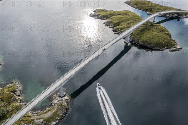 Aerial view of bridge connecting islands at the norwegian coast, motor boat below the bridge, Norway, Europe
