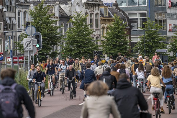 Central cycle path on Smakkelaarskade, at Utrecht Centraall station, in the centre of Utrecht, lanes for pedestrians, cyclists and cars are separated, waiting at traffic lights, heavy traffic, Netherlands