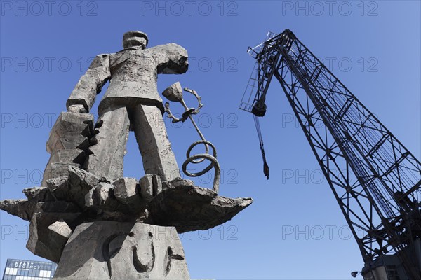 Hans Albers statue, bronze sculpture by sculptor Jörg Immendorf, and old harbour crane, Düsseldorf Media Harbour, Düsseldorf, North Rhine-Westphalia, Germany, Europe