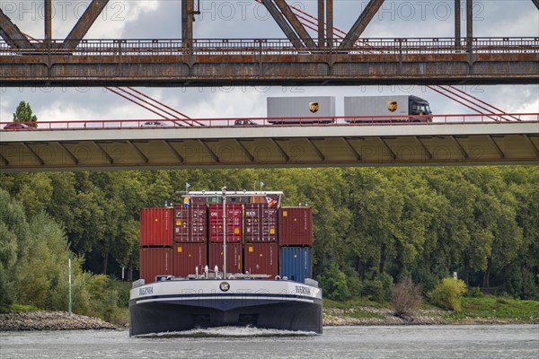 The Beeckerwerth Rhine bridge of the A42 motorway, truck traffic, in front of it the Haus-Knipp railway bridge, cargo ship on the Rhine near Duisburg, North Rhine-Westphalia, Germany, Europe