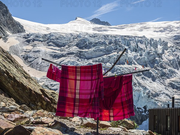 Colored bed linen dries in the sun, mountain hut Cabane de Moiry, located close to the retreating Moiry glacier, Valais, Switzerland, Europe